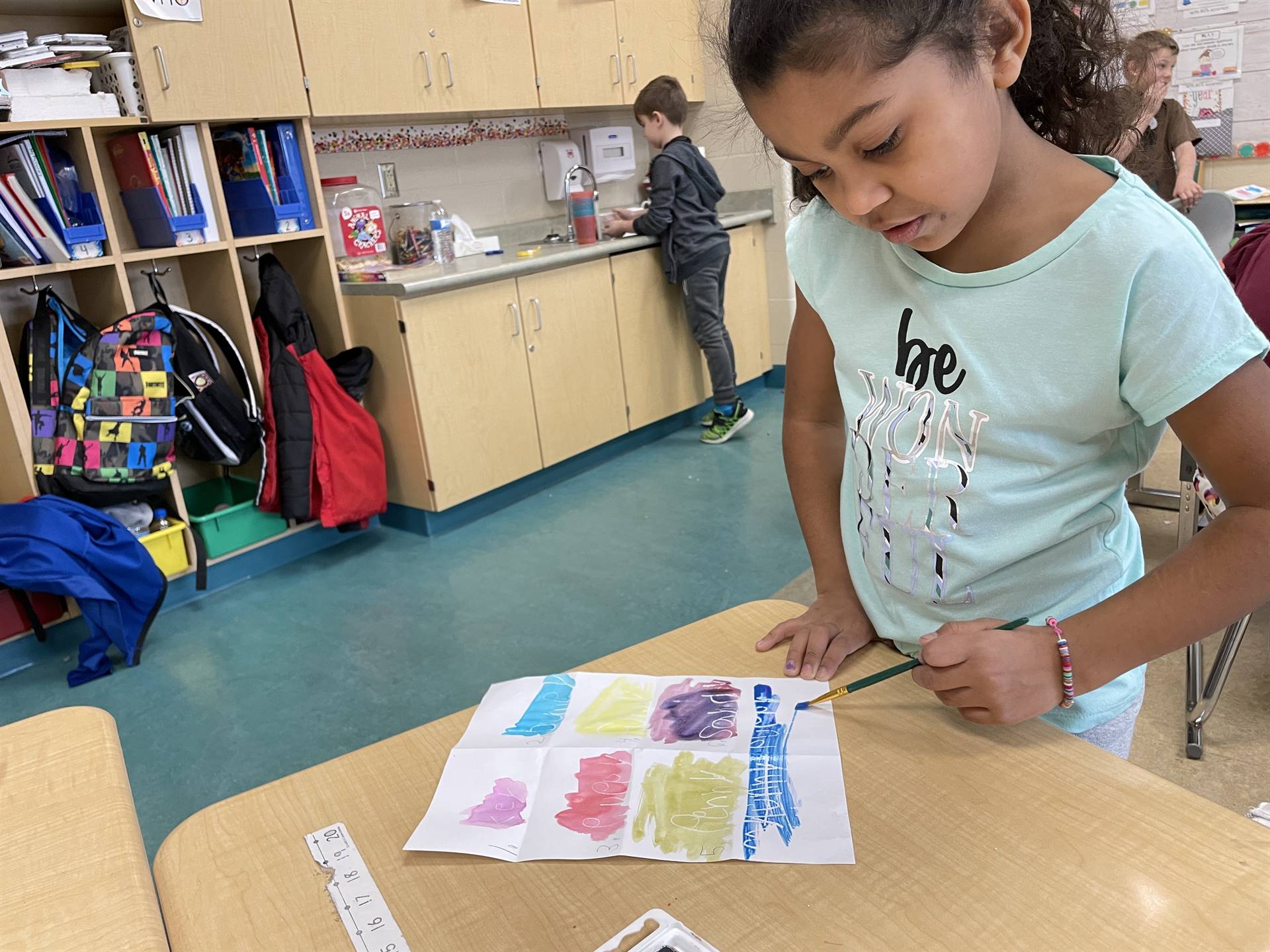 Students use white crayon and water color to practice sight words